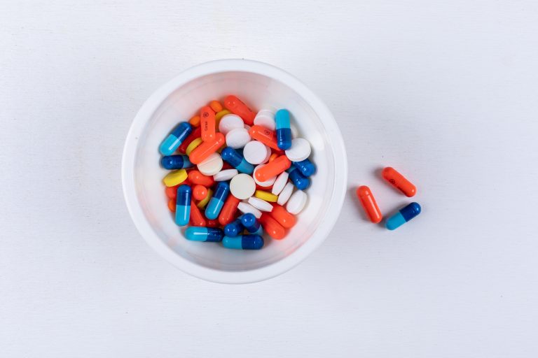 Top view pills in bowl on white background. horizontal
