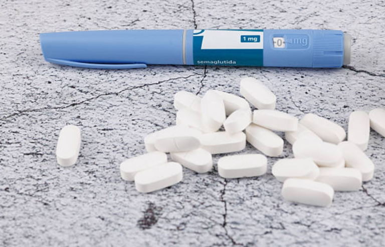 GLP-1 injection pen with white tablets on a surface