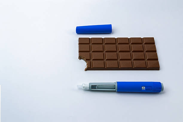 Premium chocolate bar with a bite next to GLP-1 weight loss injection pen on a light background