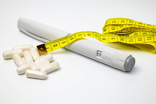 Weight loss injection pen with measuring tape and capsules representing obesity and diabetes treatment