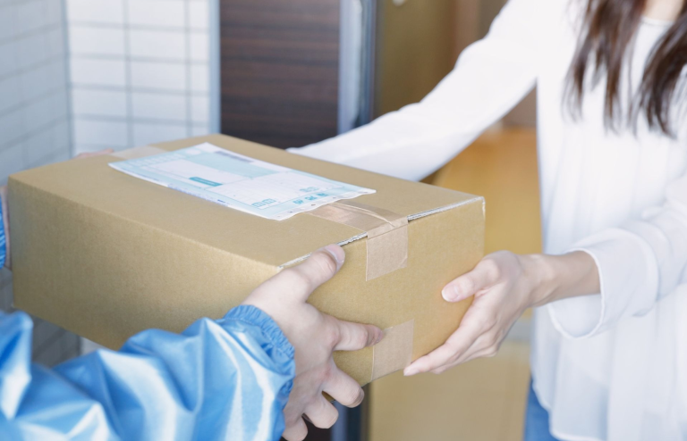 Person receiving a delivered package from a courier at the door