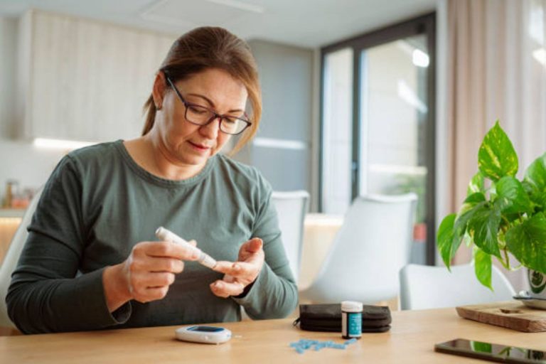 Woman using a glucose meter to check blood sugar at home