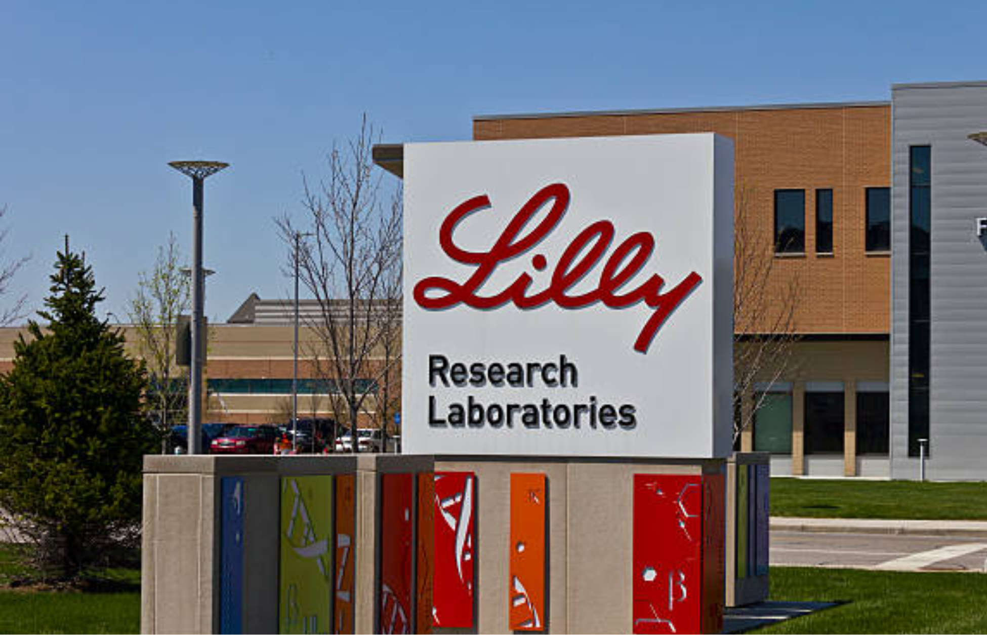 Sign outside Eli Lilly Research Laboratories building with company logo on a modern campus exterior