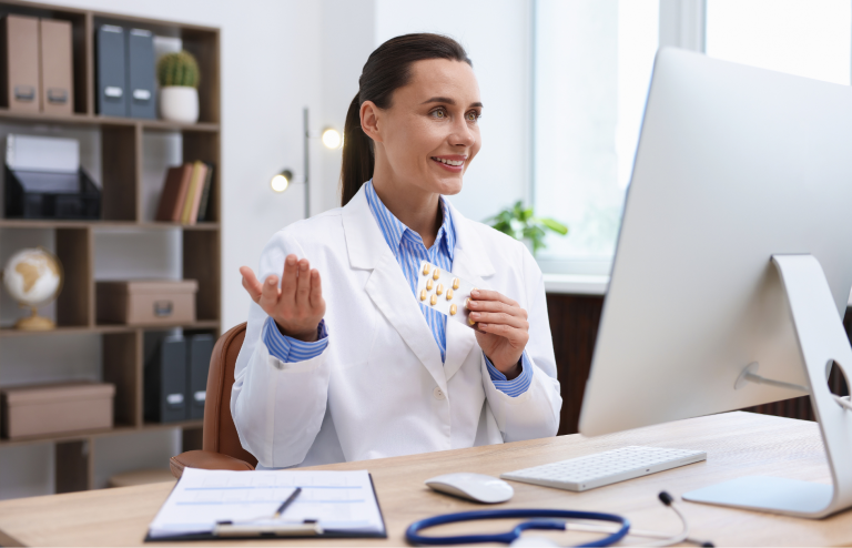 Doctor holding blister pack of pills during a telehealth consultation