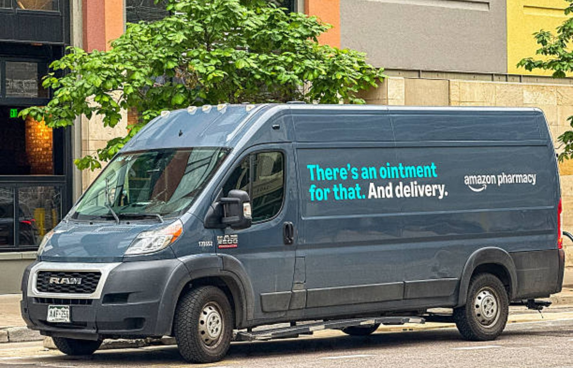 Amazon Pharmacy delivery van parked on a city street promoting ointment delivery services.