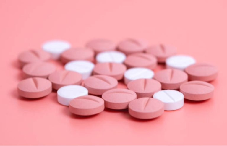 Close-up of pink and white oral tablets representing GLP-1 medication for obesity and type 2 diabetes.