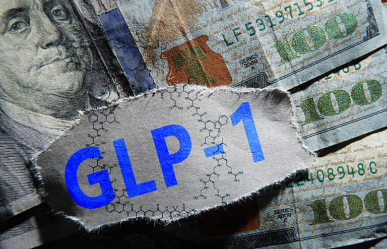 GLP-1 text displayed over U.S. dollar bills symbolizing the growing financial impact of GLP-1 medications.