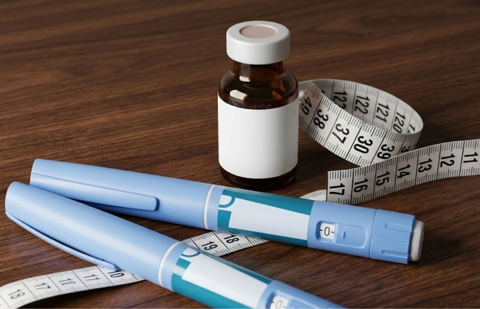 GLP-1 injection pens, medicine vial, and measuring tape representing weight loss treatment.