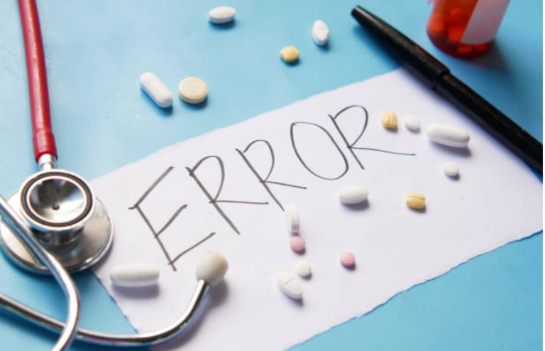Medical error concept with prescription pills, a stethoscope, and the word "ERROR" written on paper.