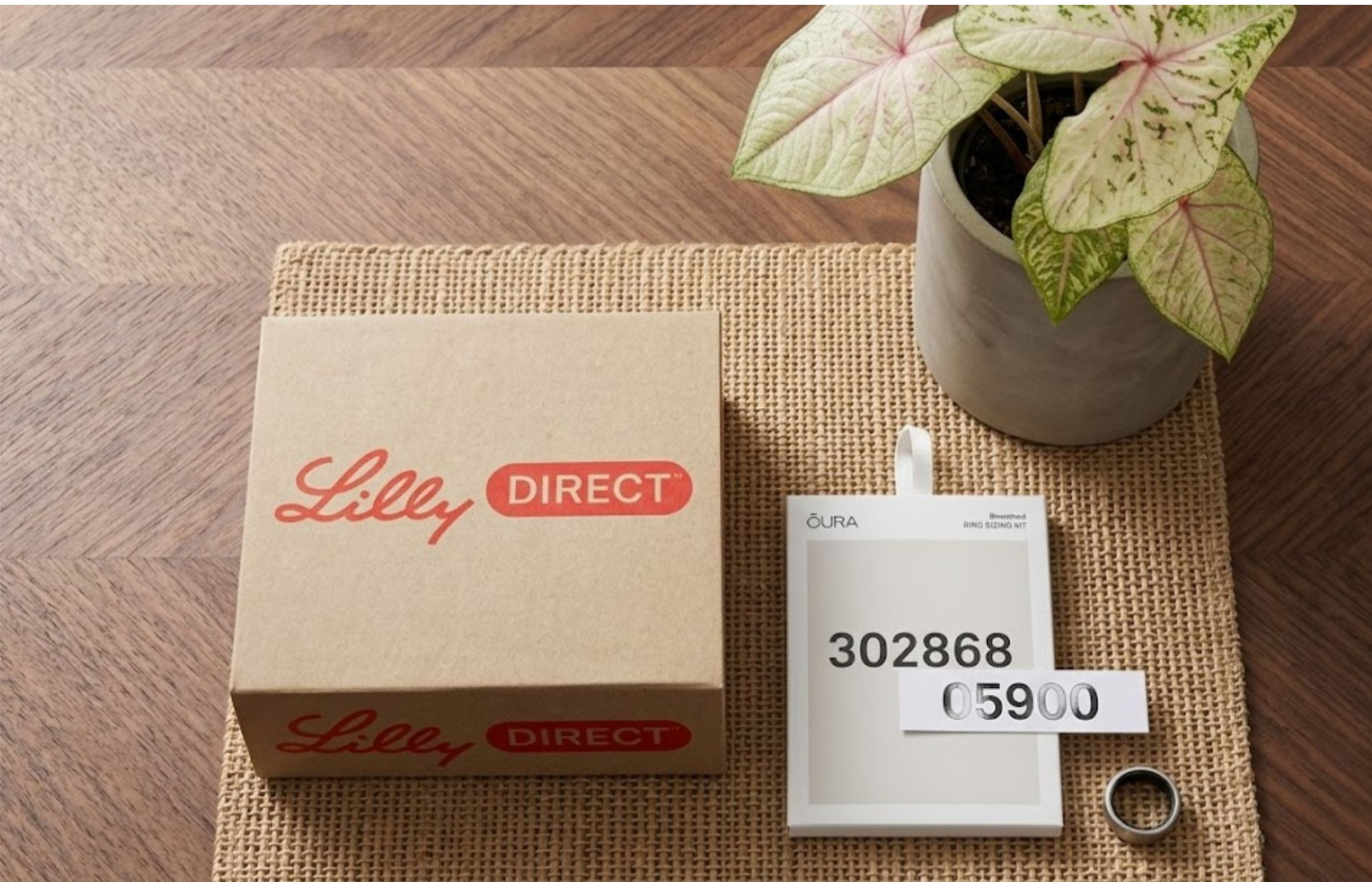 LillyDirect package displayed beside an Oura ring sizing kit and smart ring on a table, highlighting their partnership for GLP-1 therapy support.
