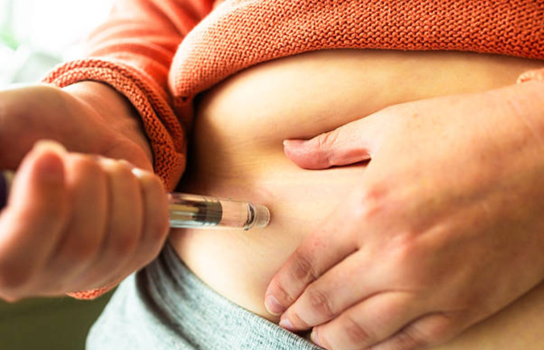 Person self-administering an injection into the abdomen for weight loss or diabetes treatment.