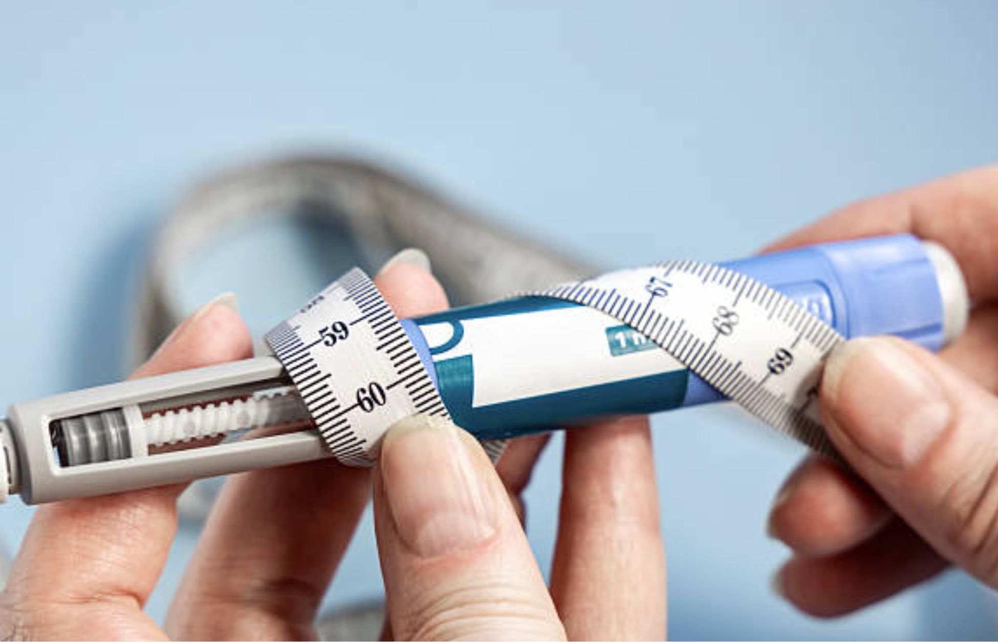 GLP-1 weight loss injection pen wrapped with a measuring tape