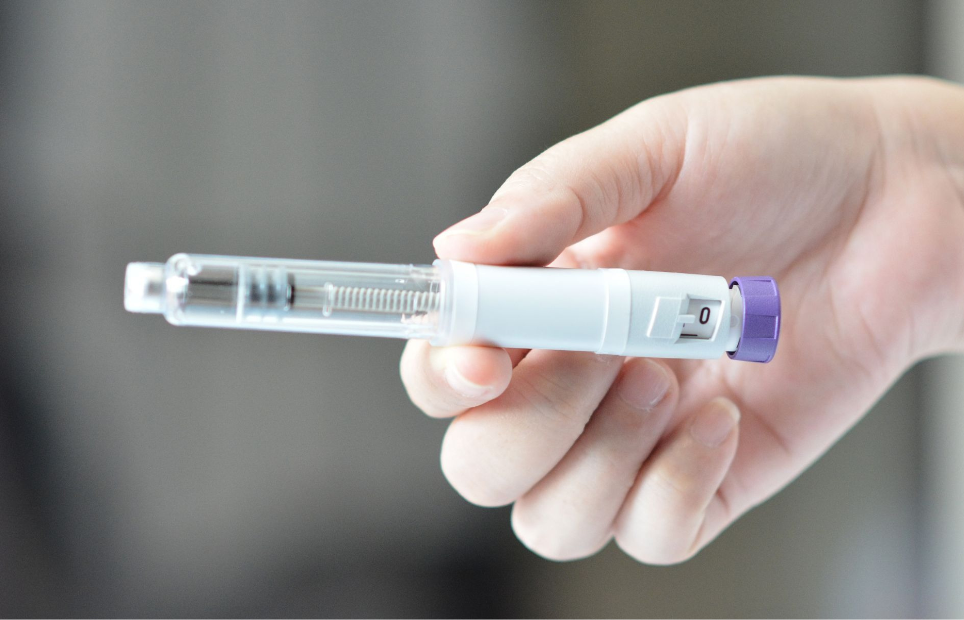 Hand holding a GLP-1 injection pen used for diabetes or weight loss treatment