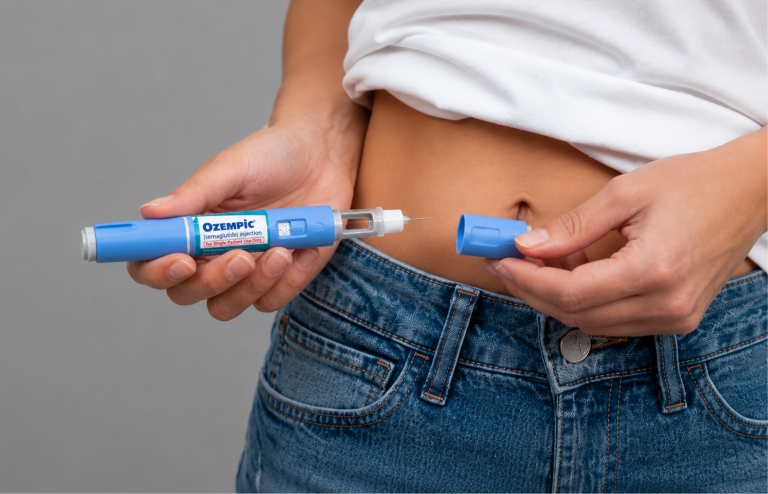 Open Ozempic injection pen held near the abdomen.