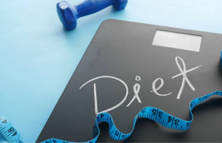 Digital scale with measuring tape and dumbbell for weight management.