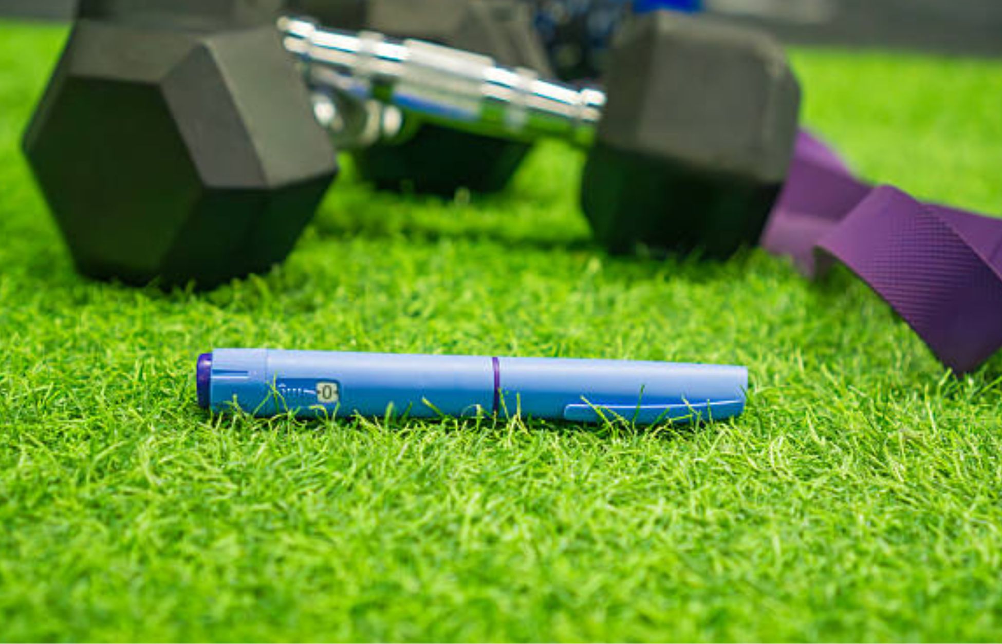 Blue weight-loss injection pen placed on artificial grass beside dumbbells and a resistance band, representing personalized obesity treatment.