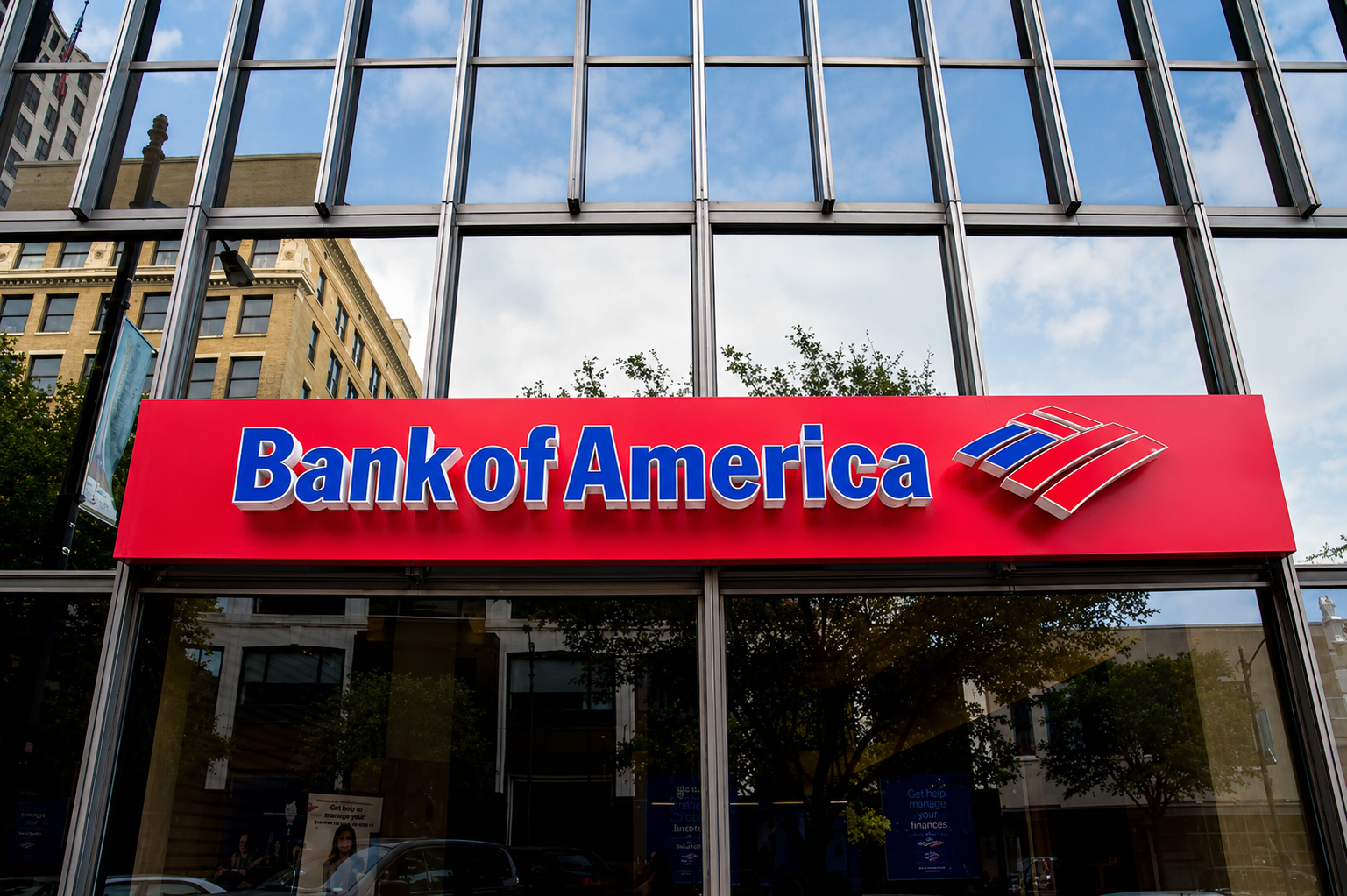 Bank of America branch entrance with the company logo displayed on a red storefront sign, representing employer-sponsored healthcare and GLP-1 medication coverage.